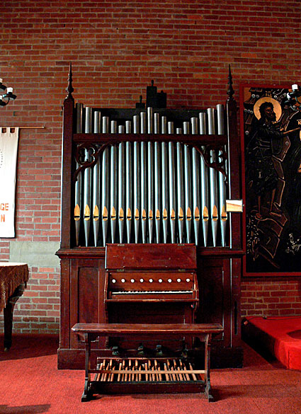 St George's Church, Travancore: the organ, viewed from the nave, showing new case finials and carved brackets